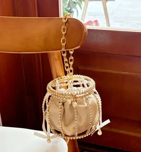 Elegant rhinestone pearl cage bucket bag detail, shiny metal chain velvet handbag.