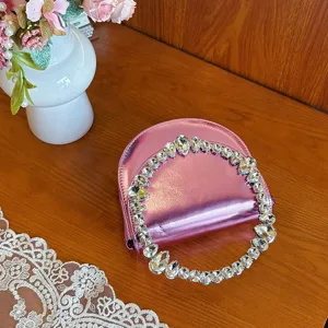 Pink metallic evening handbag featuring a stunning rhinestone circle handle for elegant style.