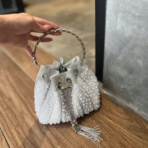 Detalle de bolso cubo de perlas con asa anillo metal strass y borla de cadena de cristal.