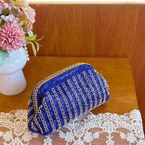 Close-up detail of a luxurious blue rhinestone evening clutch bag with sparkling crystal grid pattern.