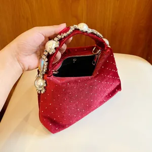 Hermoso bolso de noche de terciopelo rojo con asa de perlas y estrás, detalle chic.