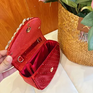 Red velvet rhinestone evening bag detail view, showing interior structure and golden hardware.