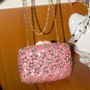 Vue détaillée du sac boîte clutch floral en strass rose de luxe avec chaîne dorée élégante.