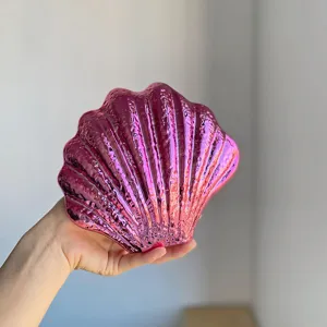 Metallic pink acrylic shell clutch bag detail, glossy evening purse held in hand, stylish design.