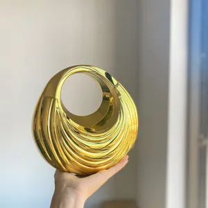Gold metallic pleated circular handbag detail, stylish acrylic ring handle design.
