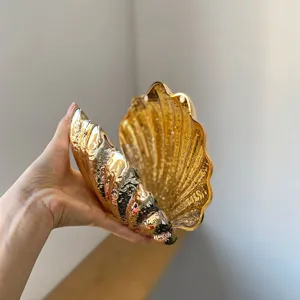 Gold shell acrylic evening clutch detail shot, glossy metallic finish party shoulder bag.