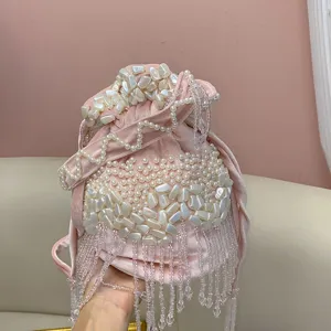 Vue détaillée du sac seau en velours rose avec perles faites main et franges en cristal.