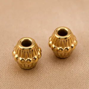 Vue de detail de perles en acier inoxydable vintage avec rayures pour creation de bijoux.