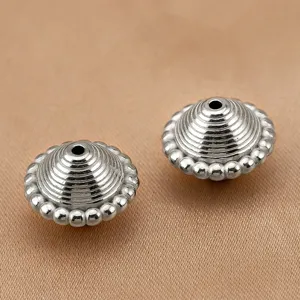 Détail de perle toupie en acier inoxydable avec texture rayée superposée pour bijoux DIY.