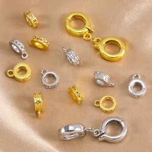 Close up detail of various brass round spacer beads and charm clasps for DIY jewelry making.
