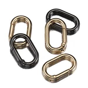 Close-up detail of alloy oval spring rings, metal clasp clips in gold and black for bags.