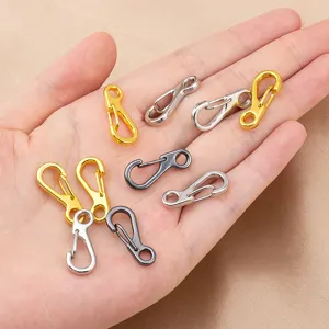 Close up of mini zinc alloy S-shape spring clasps in assorted metallic colors for DIY jewelry.