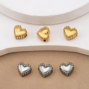 Perline a cuore in acciaio inossidabile con dettaglio bordo perlinato, ideali per creazione gioielli.