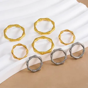 Anello bambù in acciaio inossidabile dettaglio cerchi chiusi dorati e argentati design minimalista.