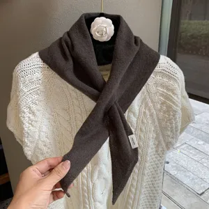 Knit triangular scarf detail, brown wool neck warmer, cozy autumn fashion accessory.