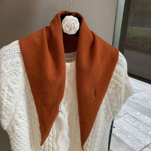Orange knitted triangular scarf detail, cozy autumn neck warmer and chic stylish small shawl.