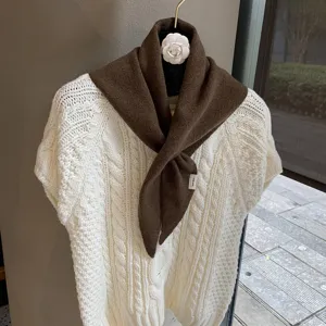 Brown knit triangular scarf detail, cozy wool neck warmer styled with knit sweater.