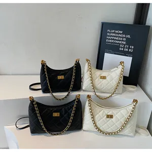 Chic quilted chain shoulder bag set in black and white, featuring a classic turn-lock closure.