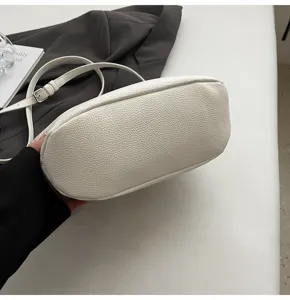 Weißer Leder Eimer Tasche Detailaufnahme mit exquisiter Textur und verstellbarem Gurt.