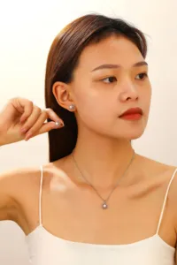Gedetailleerde close-up van de zilverkleurige parelketting en oorbellen set met bloemdesign.