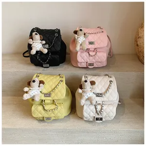 Vue détaillée de mini-sacs à dos matelassés tendance avec adorables pendentifs chien et chaînes.