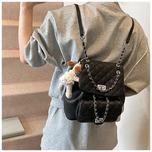 Gros plan sur le sac à dos en cuir matelassé noir avec bretelles en chaîne et fermoir tournant.