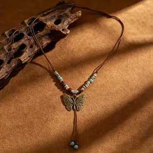 Λεπτομέρεια κοντινού πλάνου vintage boho κολιέ πεταλούδας με πολύχρωμες κεραμικές χάντρες.