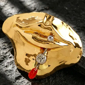 Exzentrische goldene Lippen-Brosche mit Piercing-Detail, kreatives Accessoire für Kleidung.