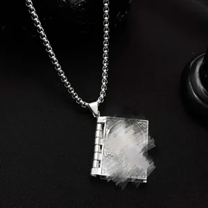 Detalle del collar con colgante de libro vintage en plata con grabado detallado.