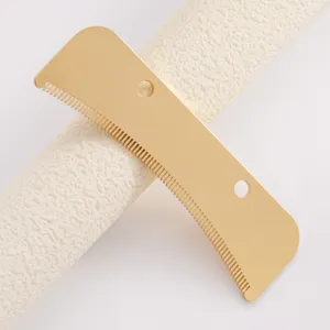 Gros plan de la lame de peigne de toilettage pour animaux en metal dore aux dents fines.