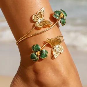 Gros plan détaillé du bracelet de cheville papillon doré et fleur verte élégant.