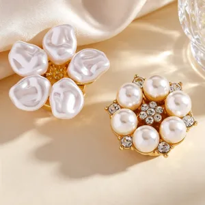 Close-up detail of exquisite pearl and crystal flower buttons, elegant metallic base trim.
