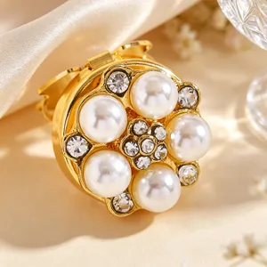 Detailed closeup of the gold-tone floral collar clip featuring faux pearls and sparkling rhinestones.