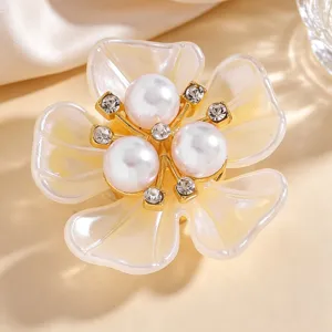 Close-up detail of exquisite floral collar clip with pearls and rhinestones for women.