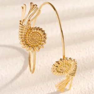 Close up view of the gold ammonite shell arm bracelet, ocean style fashion jewelry.