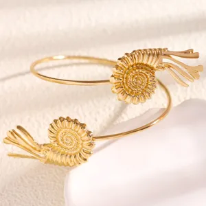 Detailed close-up of the gold-tone shell open arm cuff, featuring unique marine style design.
