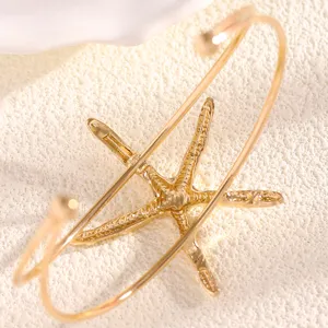 Detail view of the gold starfish open arm cuff, featuring beach style marine jewelry.