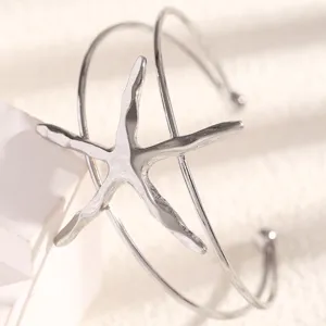 Close-up detail of silver starfish arm bangle, showcasing unique marine theme beach jewelry design.