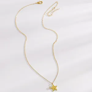 Détail de collier étoile plaqué or avec pendentif smiley mignon et chaîne fine.