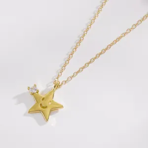 Détail en gros plan d'un collier pendentif étoile dorée avec sourire creux et zircon transparent.