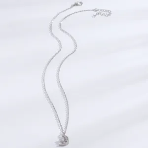 Vue détaillée du collier pendentif lune et étoile argenté avec des pierres zirconia.
