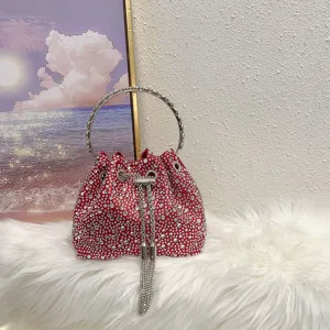 Stunning red rhinestone mini bucket bag with metal ring handle and chic crystal tassel strap.