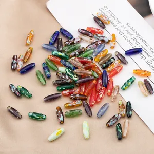 Detailaufnahme von bunten 4x12mm Glasschiffchenperlen für handgemachte DIY Schmuckaccessoires.