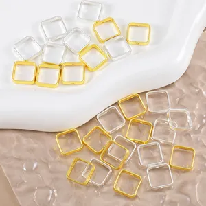 Nahaufnahme von quadratischen Metall-Anhängerverbindern in Gold und Silber für Schmuck DIY.