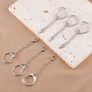 Detail shot of silver metal keychains with D-buckles and chains for DIY jewelry making.