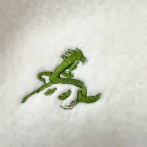 Nahaufnahme Detail des weichen warmen flauschigen Winterschals mit grüner Pferdebestickung.
