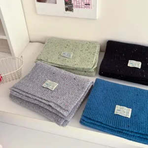 Cozy winter knit woolen scarf for women, featuring colorful flecks and a woven label design.