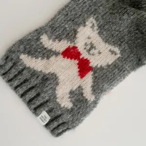 Grey knit neck warmer scarf with cute bear pattern, cozy winter accessory detail.