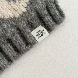Detailed view of cozy knit winter neck warmer scarf with cute brand label texture.