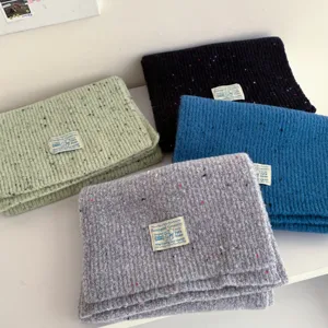 Detail view of winter colorful speckle knit wool scarves in multi-colors, soft warm fabric texture.